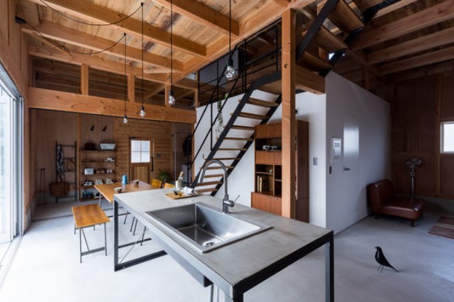 The kitchen and dining spaces are united with the entryway, there's a metal functional space, a wood and black metal dining set and some open shelving The kitchen and dining spaces are united with the entryway, there's a metal functional space, a wood and black metal dining set and some open shelving