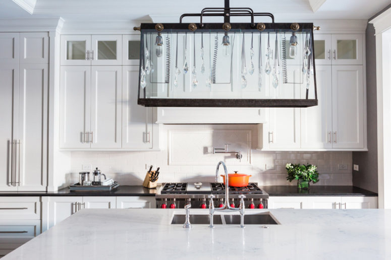 The kitchen is white and rather traditional but the accent is made with a unique lighting fixture that blends crystal hangings and industrial details The kitchen is white and rather traditional but the accent is made with a unique lighting fixture that blends crystal hangings and industrial details