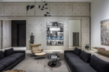 02 This is the living room that features black sofas, concrete walls and bold artworks including a human figure on the wall
