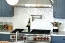 02 a glossy white tile herringbone backsplash makes the matte blue cabinets stand out