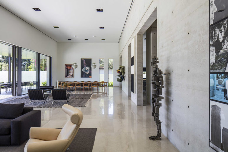 The dining space features artworks and a long table with chairs, the open layout looks very spacious The dining space features artworks and a long table with chairs, the open layout looks very spacious
