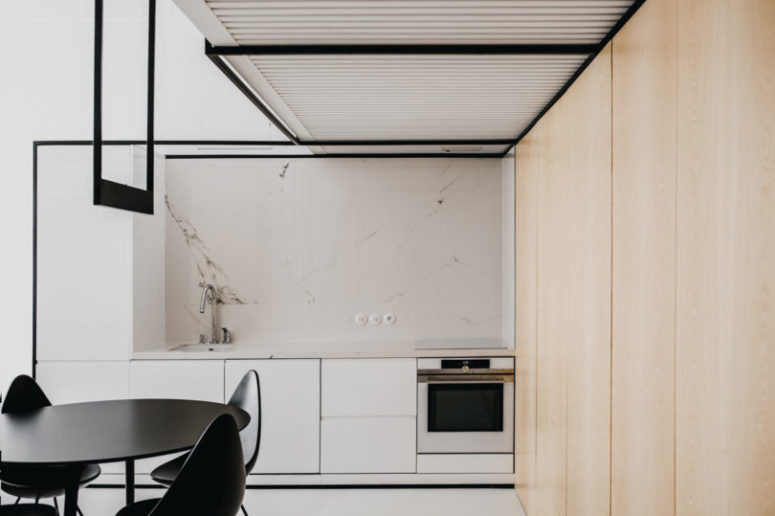 The kitchen features white cabinets with a white marble backsplash