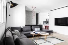 03 The living room features a large sectional grey sofa, a geo rug and eye-catchy red lights