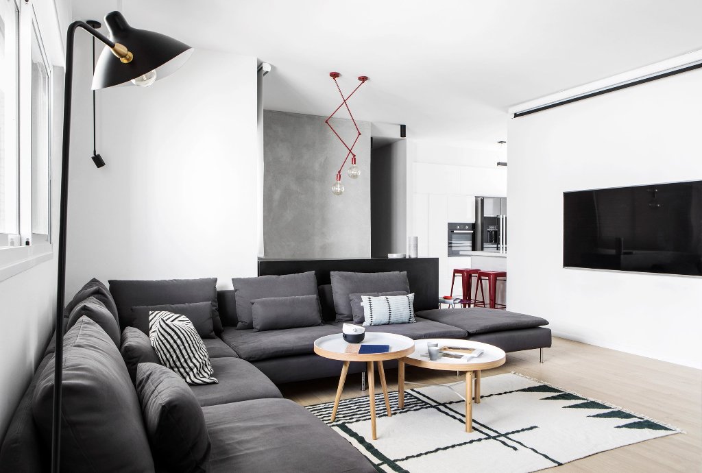 The living room features a large sectional grey sofa, a geo rug and eye catchy red lights