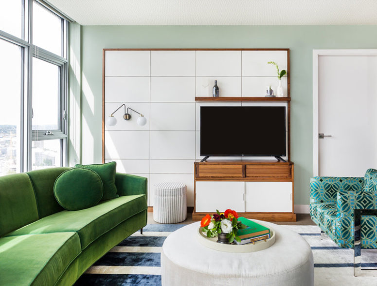 The living room is with stunning views, with an emerald sofa and bold turquoise printed chairs with mirror legs The living room is with stunning views, with an emerald sofa and bold turquoise printed chairs with mirror legs