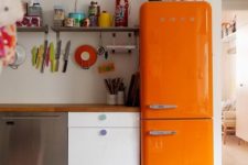 an eclectic kitchen with a bold orange Smeg fridge for a wow factor