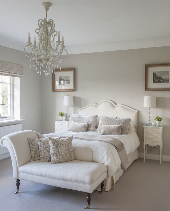a white glam chandelier and traditional lamps for the bedside
