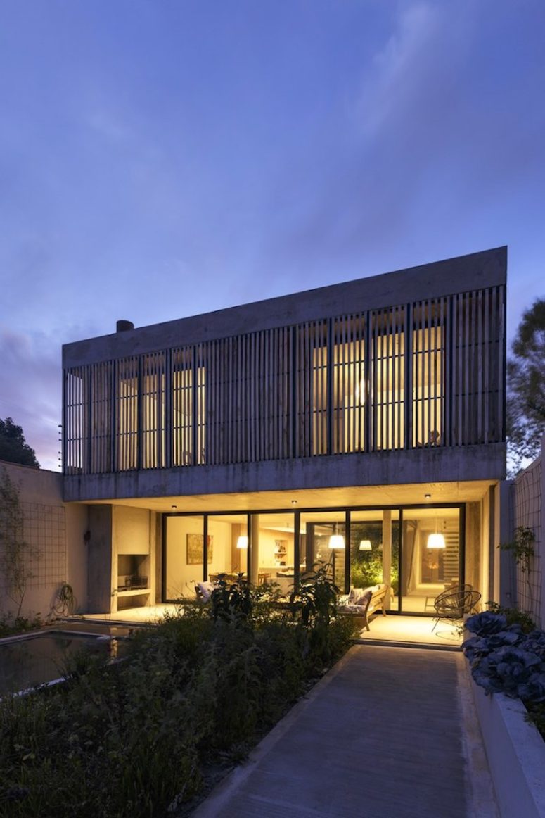 Full-height windows and sliding glass doors open the living spaces to the backyard