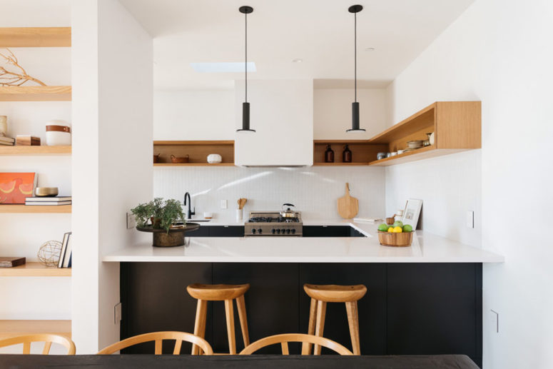 The kitchen has black cabinets and white countertops, this color scheme is used throughout the whole house