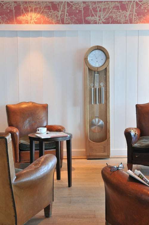 a chic traditional living room with leather armchairs and a wooden grandfather's clock