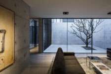 07 There’s a private courtyard clad with concrete and with a single tree growing