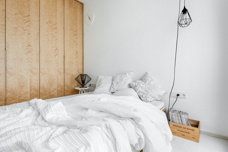 The mster bedroom is decorated simply, with a large bed, a nighstand and a crate with magazines