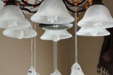 09 attach small cheesecloth ghosts to the chandelier to give your home a Halloween feel