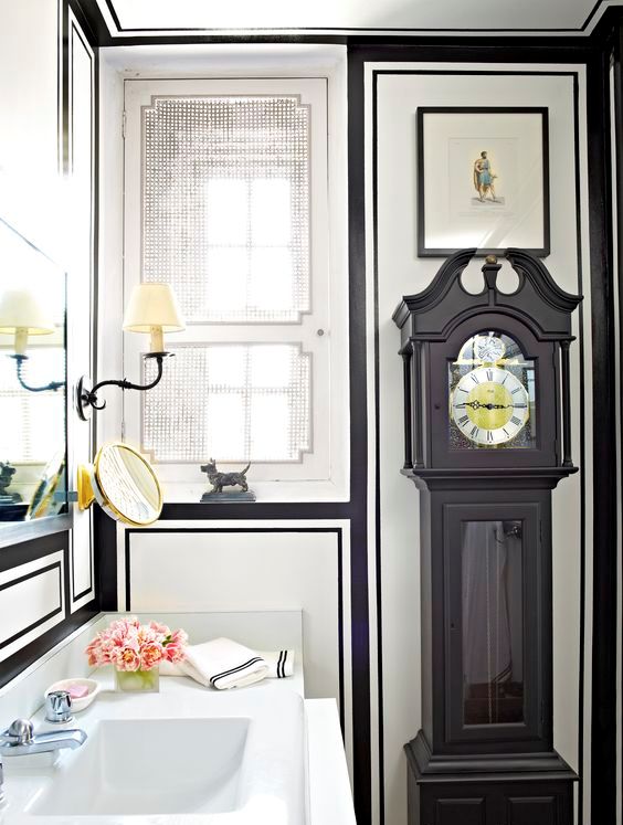 a black grandfather's clock incorporated into a chic art deco bathroom