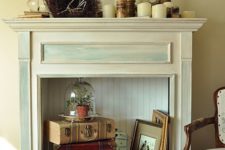 10 an antique fireplace is used for a vintage-inspired display with suitcases, a cloche piece and paintings