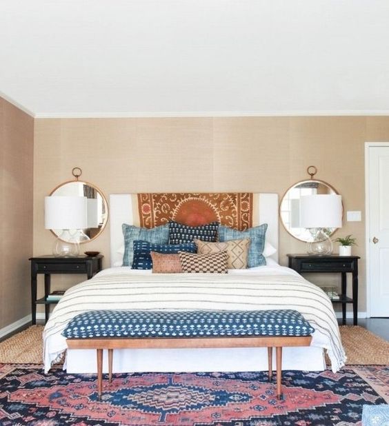 shibori pillows and an upholstered bench for a trendy feel in the bedroom