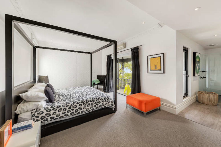 The master bedroom features a framed bed, bold pieces and a balcony to enjoy fresh air