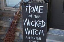 11 a black and white sign, witch’s shoes, a broom and a pumpkin is a nice combo for a porch