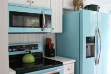 11 a blue fridge, microwave and cooker spruce up the traditional white kitchen