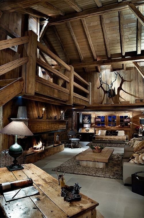 cozy rustic man cave with lots of wood, antlers, a fireplace and taxidermy