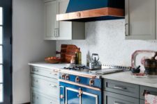 13 a deep blue kitchen stove with a copper touch and a matching hood in a grey kitchen