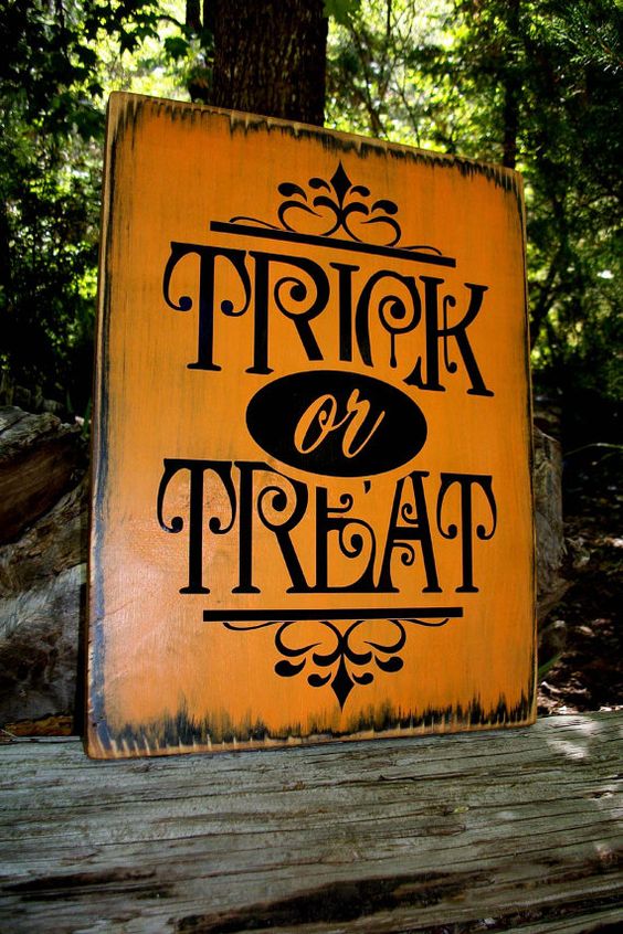 an elegant orange and black TRICK OR TREAT sign with pretty patterns