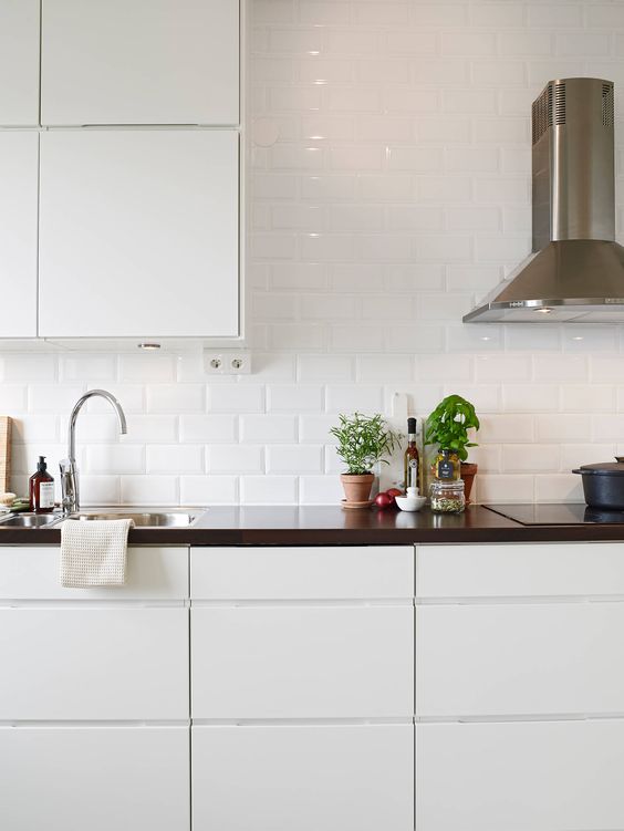 glossy white subway tile add interest and shine to a modern sleek kitchen