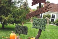 14 a large branch with colorful signs, faux fall leaves and pumpkins, a faux raven and a lantern