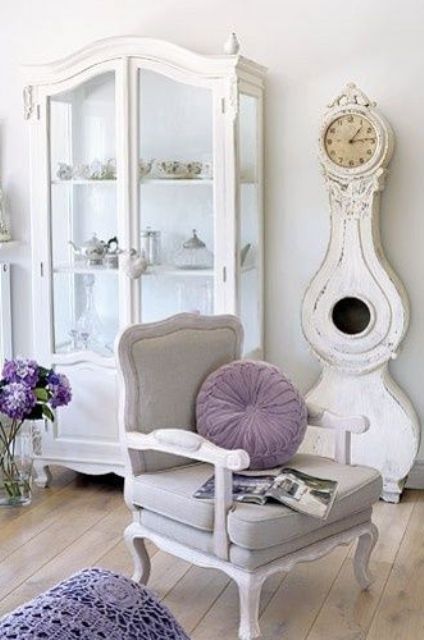 a refined chair, an antique glass armoire and a shabby chic grandfather's clock
