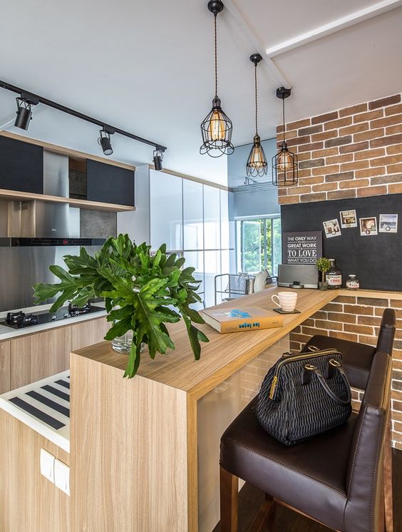 a wooden kitchen island in a modeern space is made chic with brown leather stools