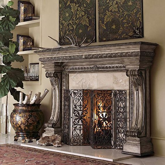 a carved casalla wood fireplace is highlighted with a forged metal screen