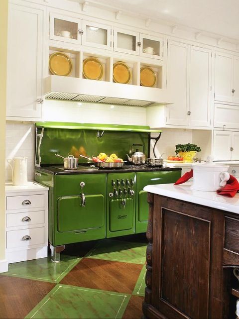 a traditional white kitchen with a green retro stove and a natural wood kitchen island