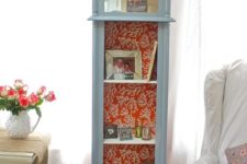 20 a grandfather’s clock repurposed into a shelf, a mirror attached and coral print wallpaper inside