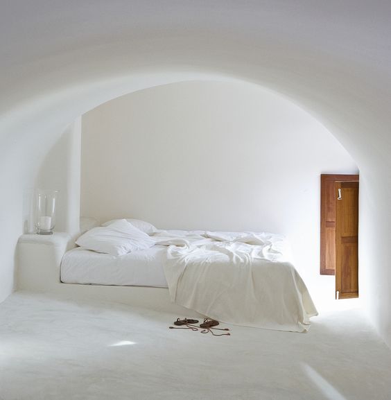 a laconic Mediterranean bedroom with a platform bed and nightstands