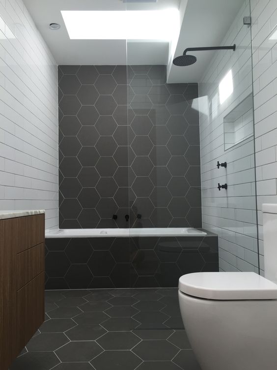 matte graphite grey hexagon tiles and white subway ones create an interesting and eye-catchy space