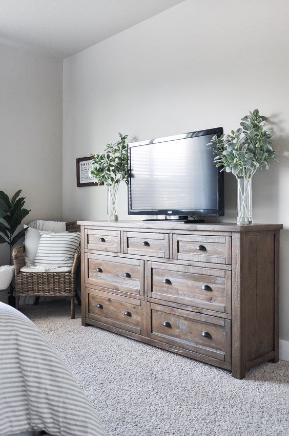 a farmhouse guest bedroom with a TV opposite the bed