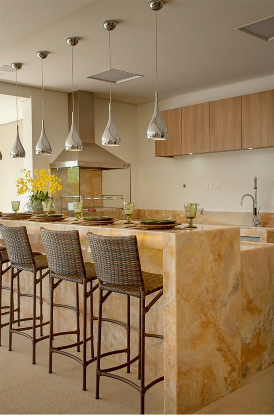 a gorgeous two-level kitchen island with a countertop for having meals made of marble