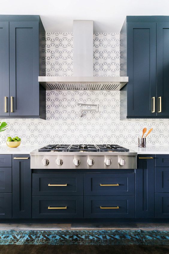 dark navy cabinets with brass handles and mosaic tiles look very eye-catching