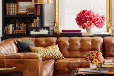 23 a luxurious brown leather sofa is accentuated with a cheetah print pillow and black leather side tables