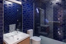 23 glossy cobalt blue tiles with white grout are a great choice for a modern bathroom with a color statement