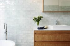 26 glossy tiles of a very light aqua shade look heavenly and turn the bathroom into a relaxing space