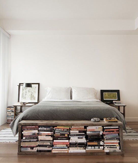 a storage bench at the foot of the bed filled with books is a cool space-saving idea