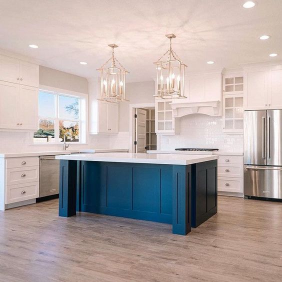 a white vintage kitchen with a cobalt blue kitchen island and a white countertop