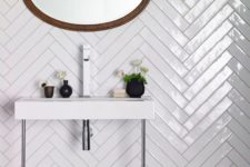 28 glossy white tiles clad in a herringbone pattern to make the bathroom more eye-catching