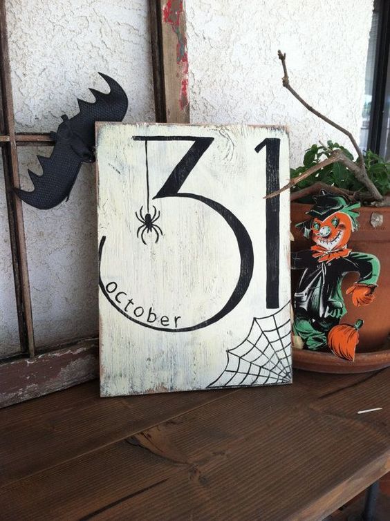 a stylish black and white Halloween sign with a spider, a web, and the date