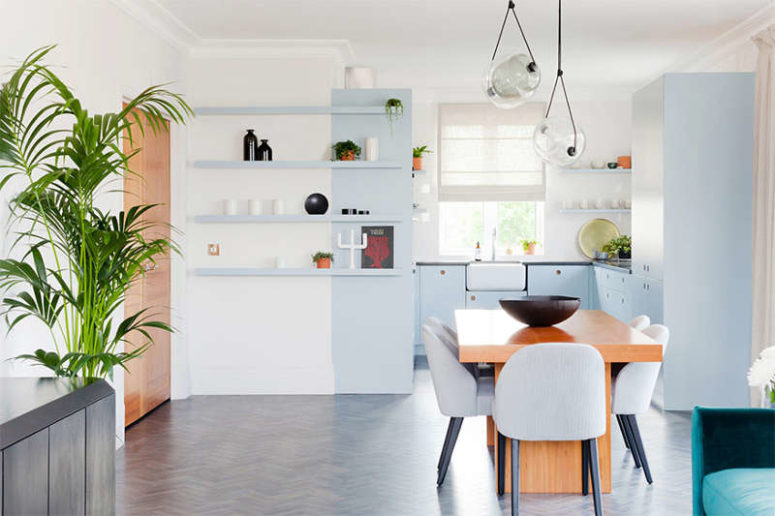 The kitchen is decorated in serenity blue, and it's united with the living space and a dining one