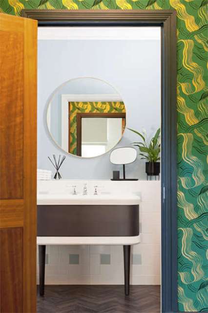 The bathroom features a black sink stand, neutral and serenity blue tiles in the shower