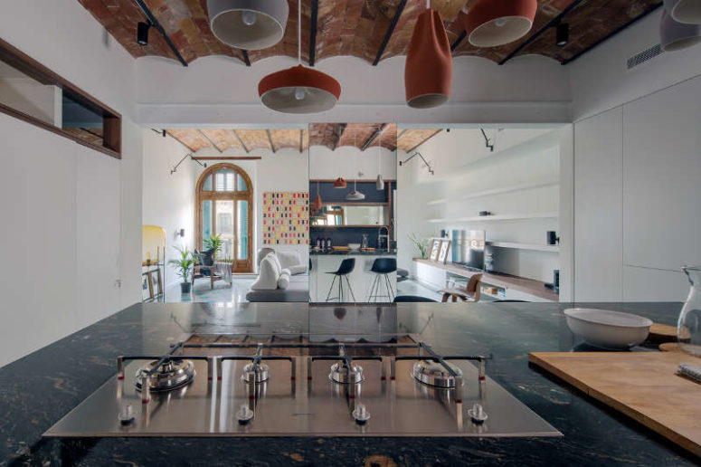 The kitchen is separated from the living room with a mirror pillar