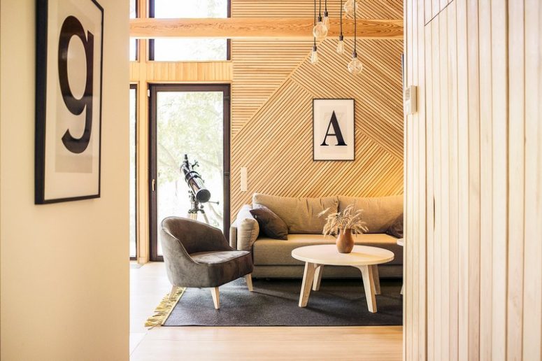 The lamps are industrial ones, the furniture is soft and comfortable and the wood in various patterns accentuates the walls no worse than some unusual wallpaper