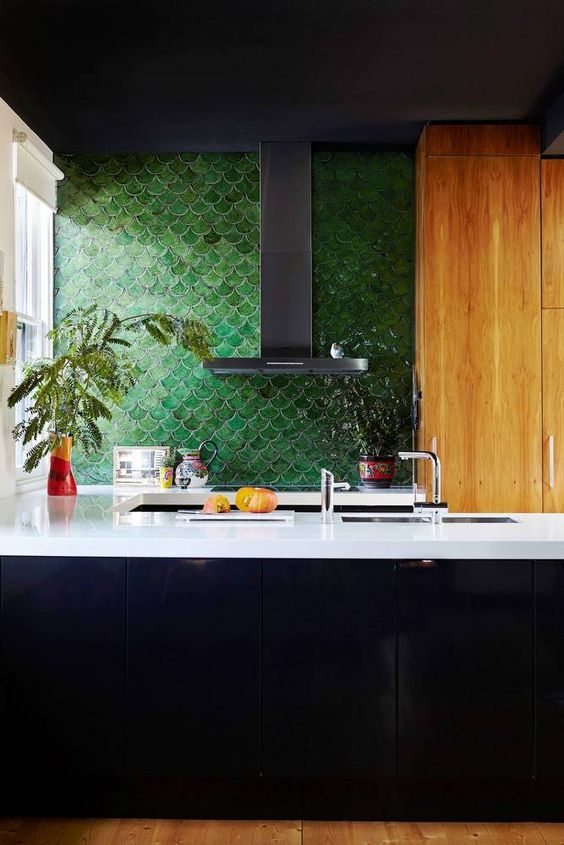 a masculine inspired kitchen with forest green fish scale tile and white countertops